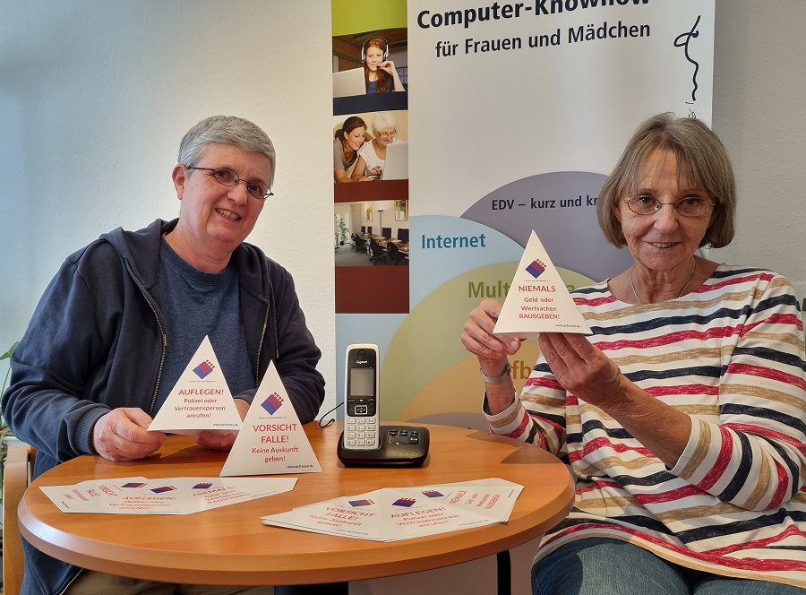 Nathalie Türich und Frau Schneider halten Exemplare der kostenlosen Aufsteller in den Händen