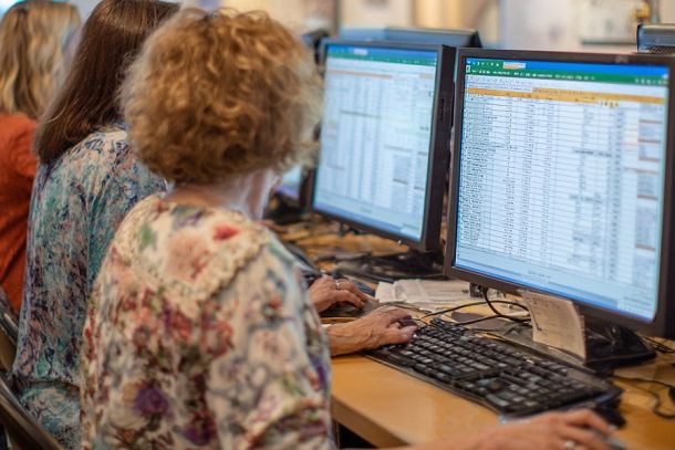 Vier Frauen sitzen an einem Tisch und halten jeweils ein Smartphone in den Händen