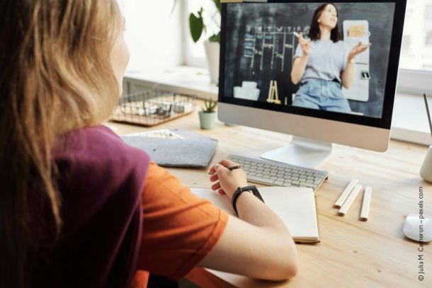 Ein junge Frau schaut bei einem Webinar zu
